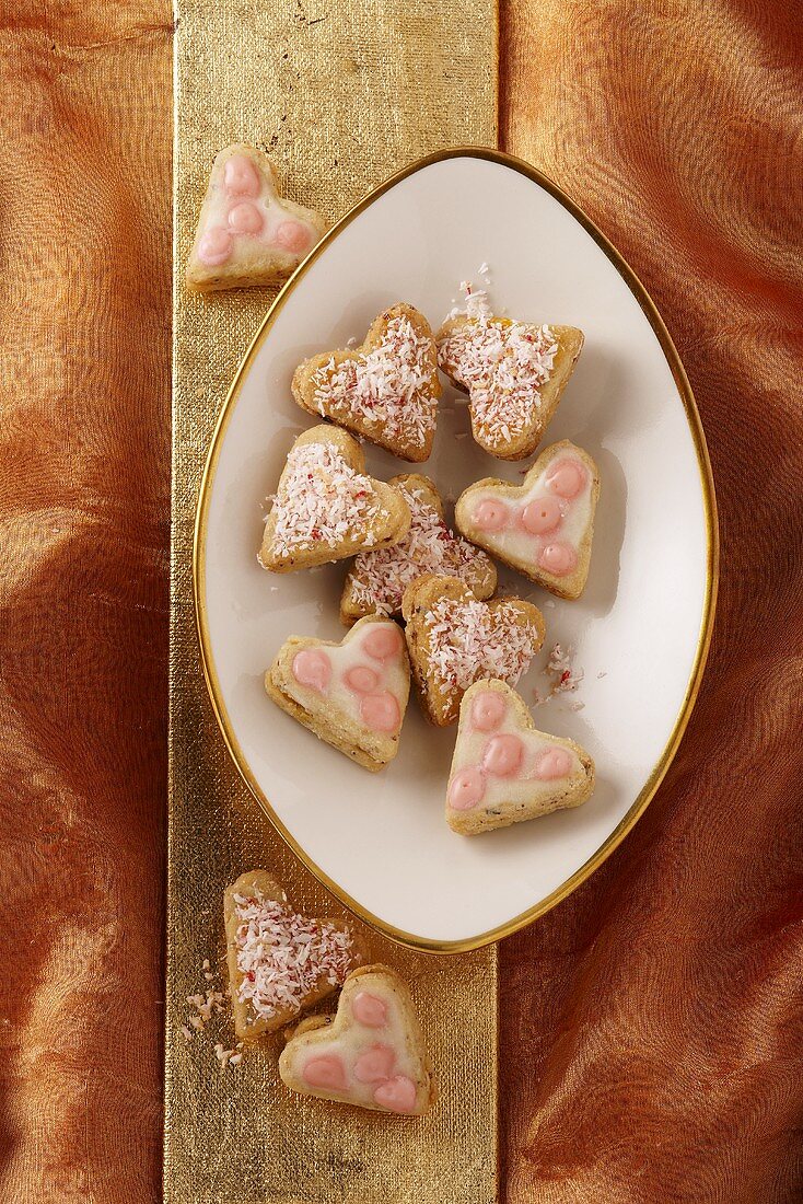 Coconut hearts & heart-shaped iced biscuits on plate (Xmas)