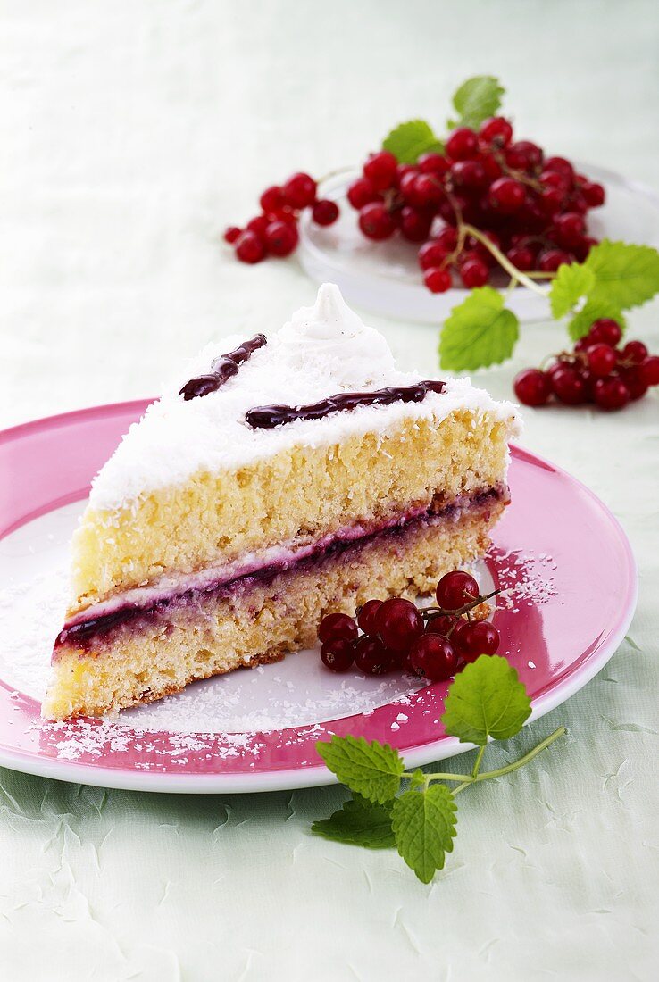 Stück Sahne-Kokos-Torte mit Johannisbeeren