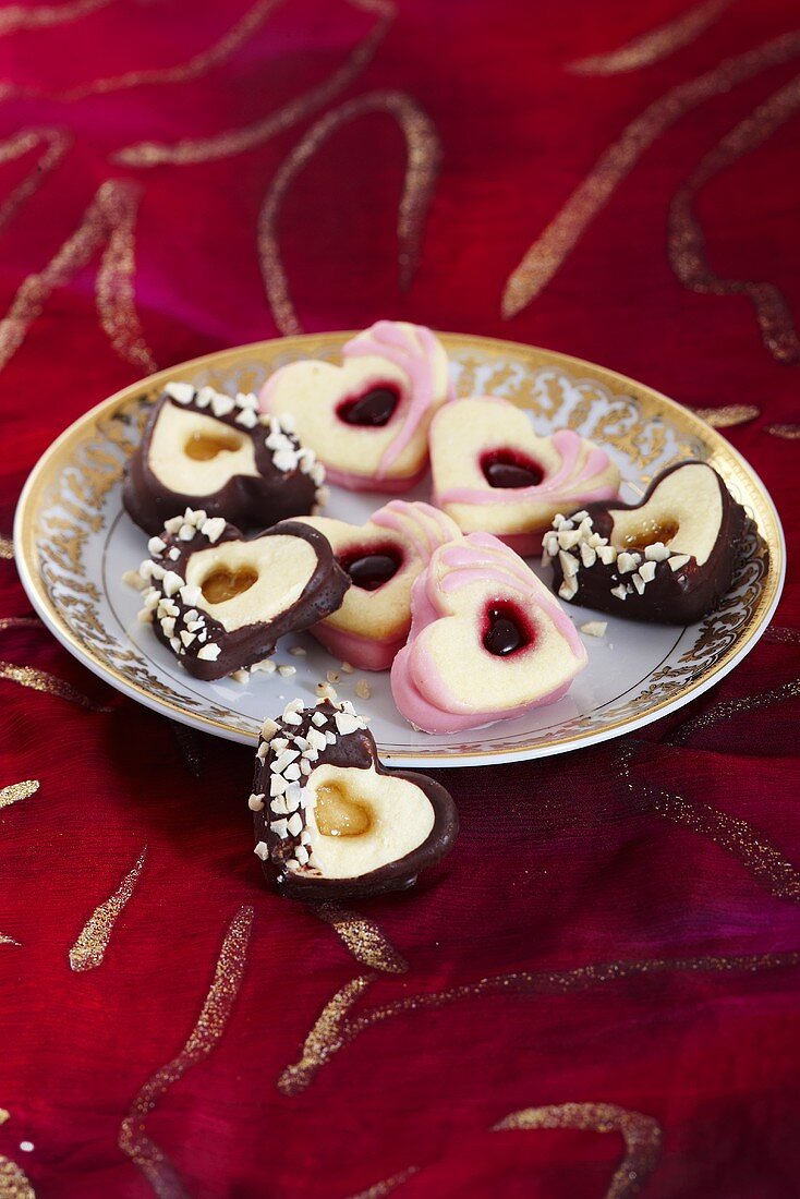 Heart-shaped jam biscuits, some with chocolate icing