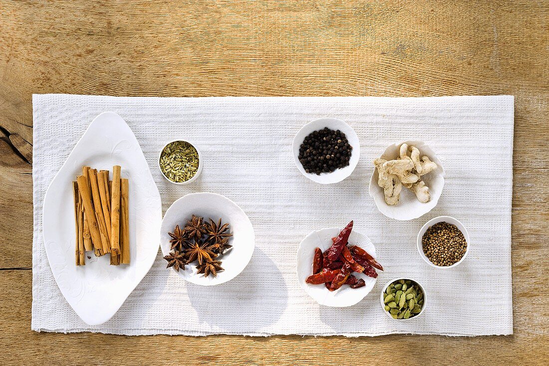 Assorted spices in small dishes on tea towel