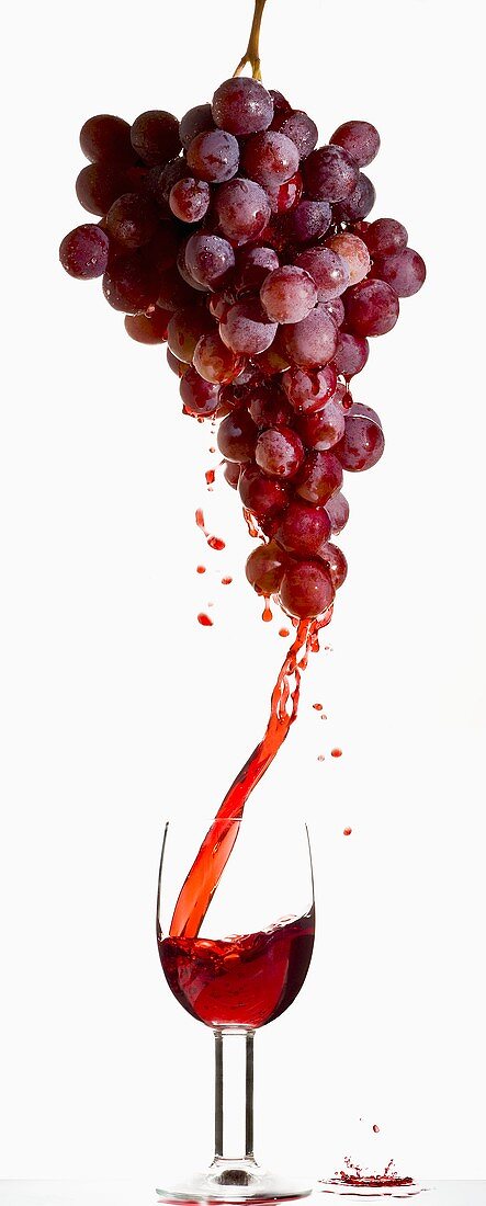 Red grape juice running into a glass