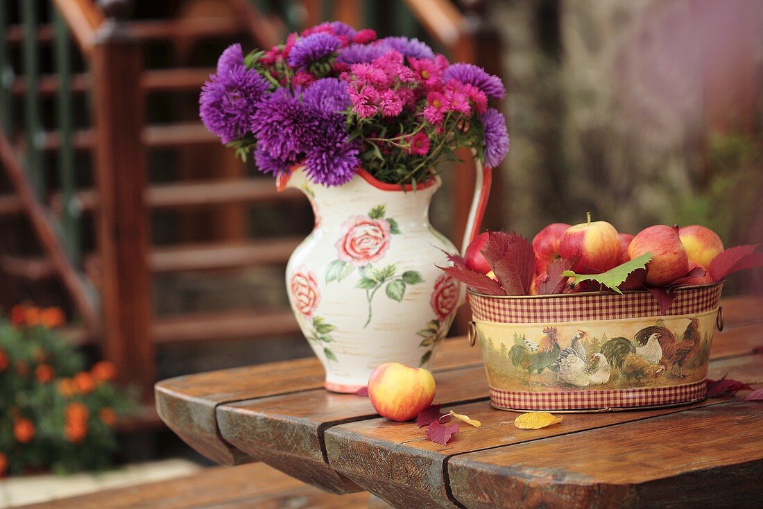 Still life with apples and jug of flowers