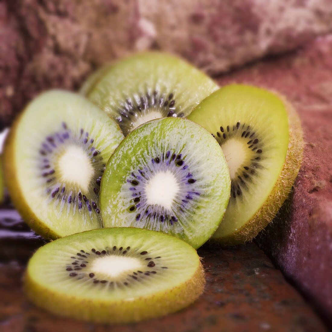 Slices of kiwi fruit on bricks