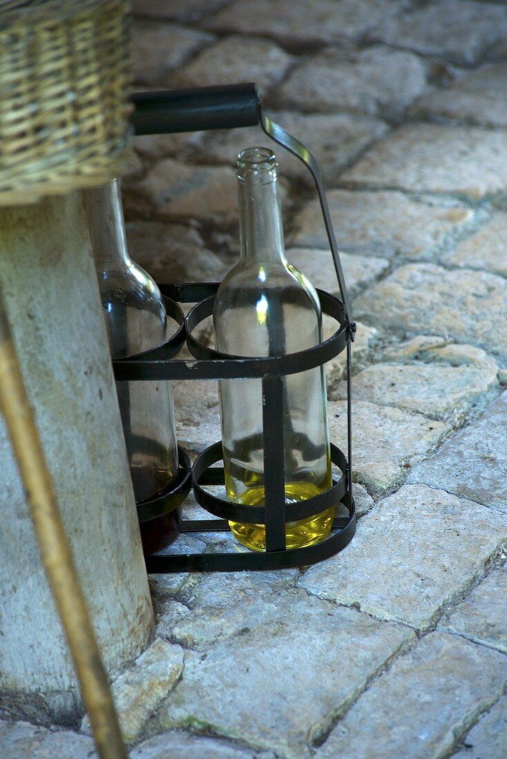 Weinflaschen im Tragekorb auf Steinboden (Schloss La Verrerie, Frankreich)