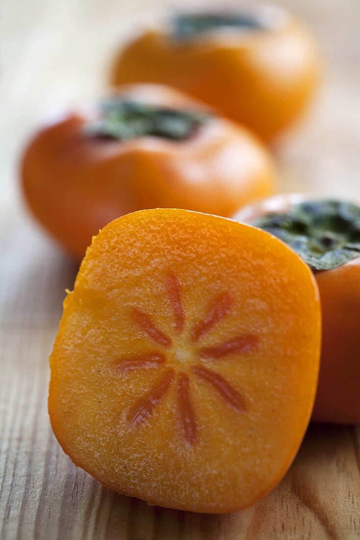 Persimmons, whole and a slice