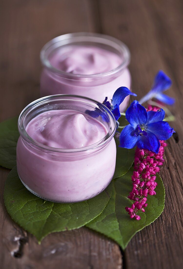 Cherry yoghurt in jars on wooden table