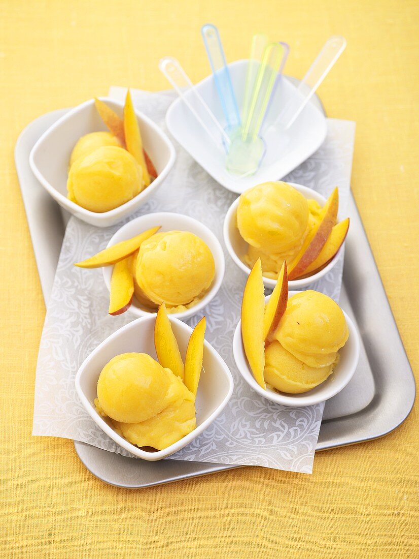 Tablett mit mehreren Portionen Mango-Eiscreme