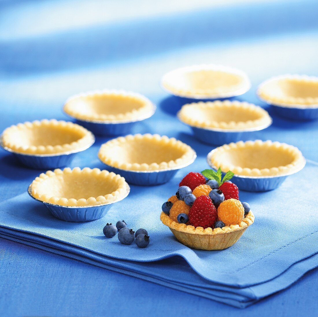 Shortcrust pastry cases, one filled with berries