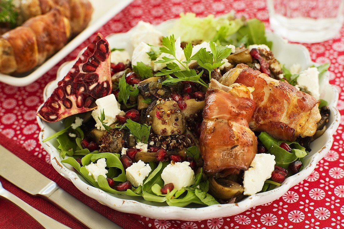 Salad with fresh goat's cheese, pomegranate and bacon rolls