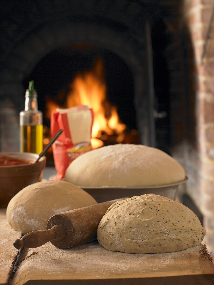 Pizza dough and ingredients in front of pizza oven