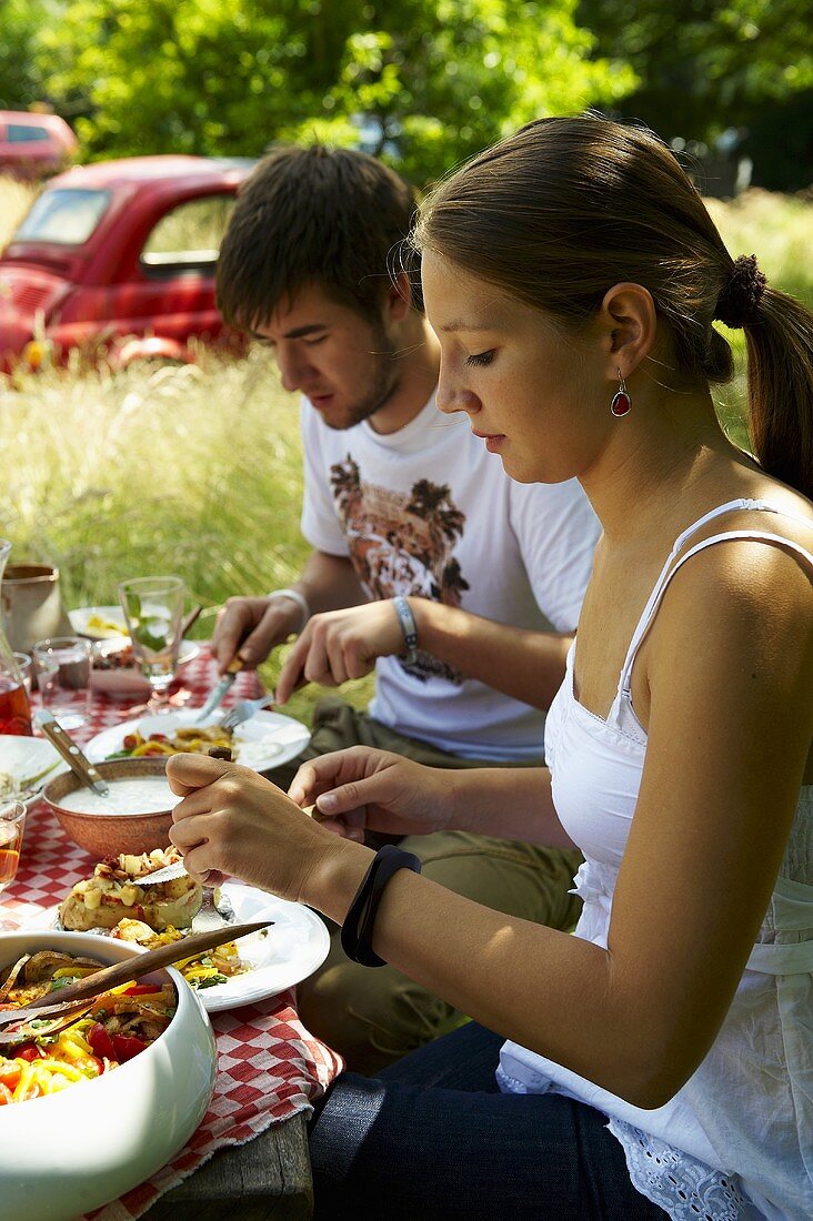 Junges Paar bei italienischer Grillparty im Freien