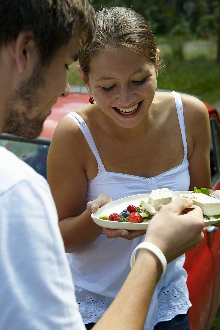 Young couple eating panna cotta with berries