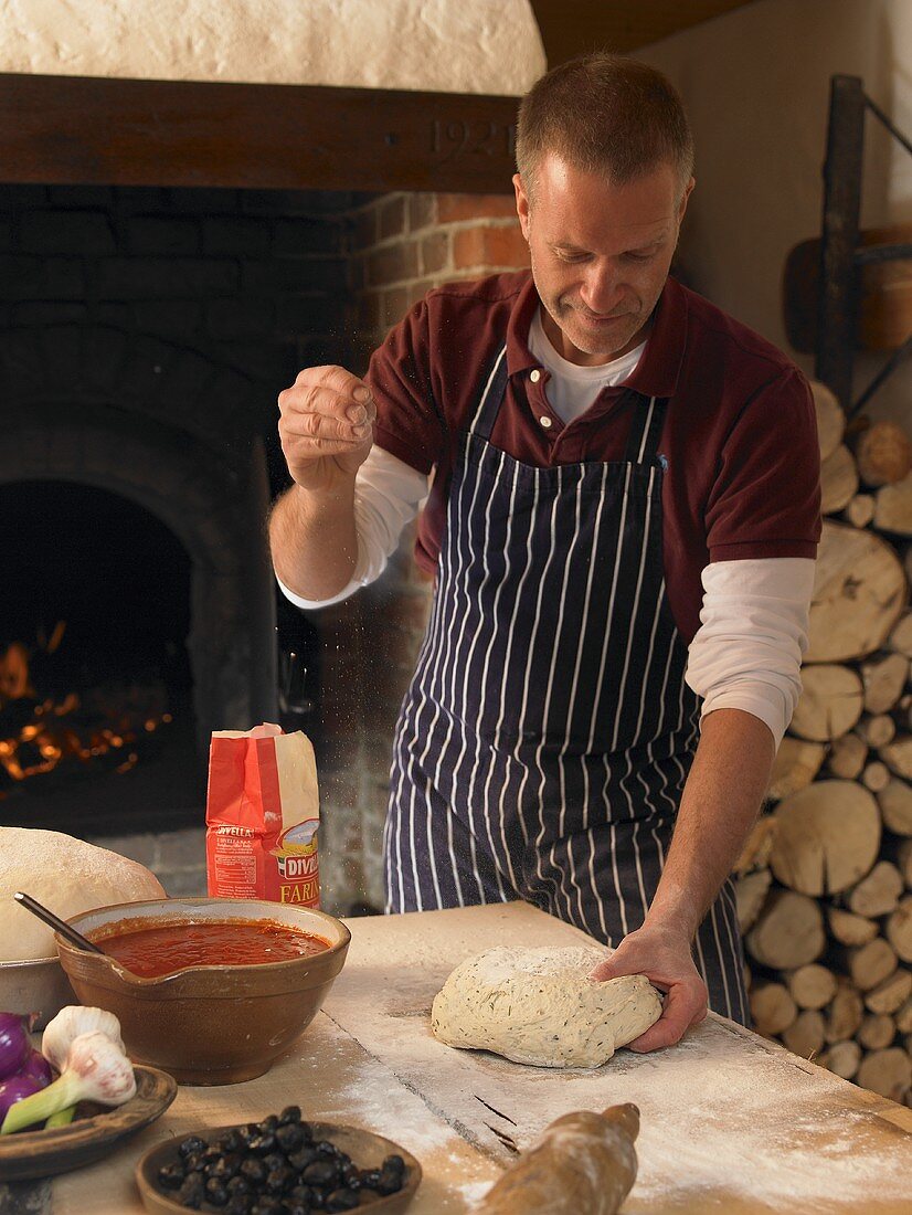 Pizza baker kneading dough