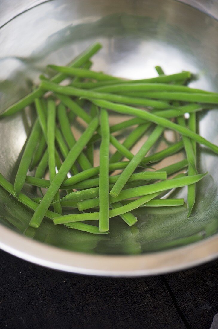 Green beans in bowl of water