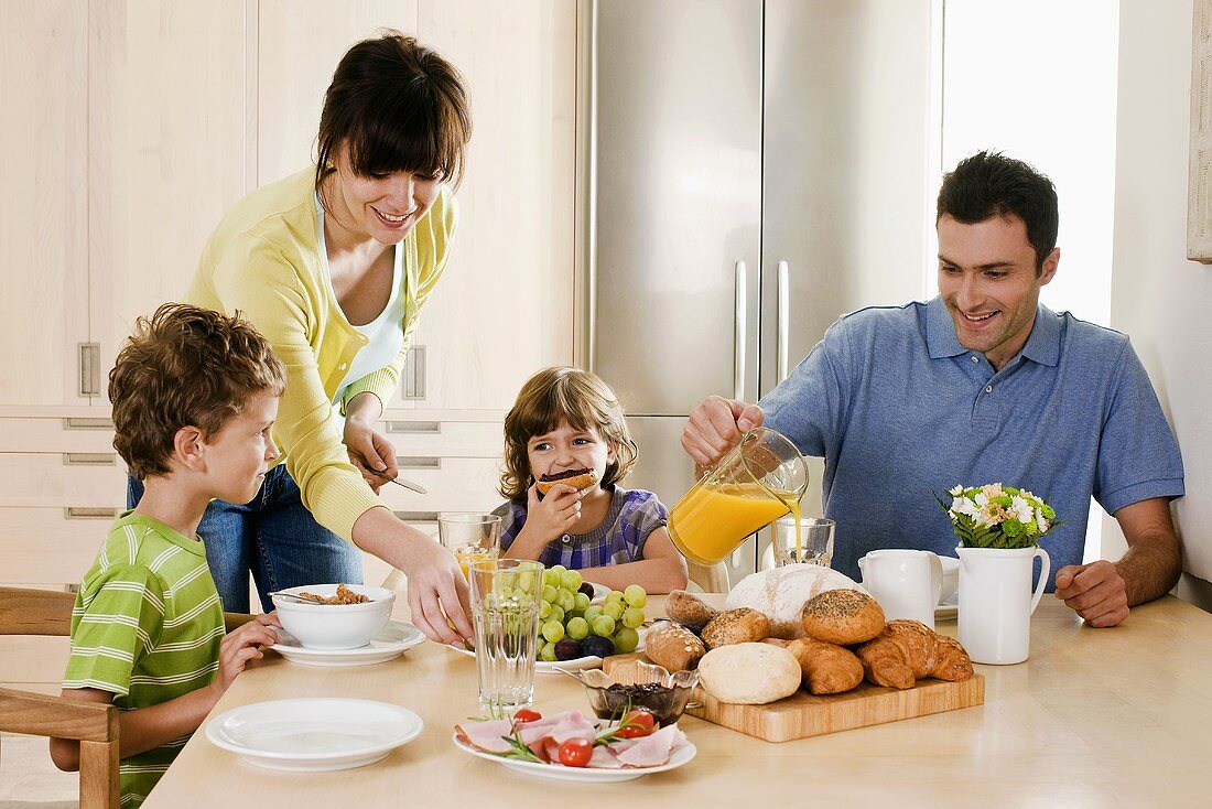 Junge Familie mit zwei Kindern beim Frühstück