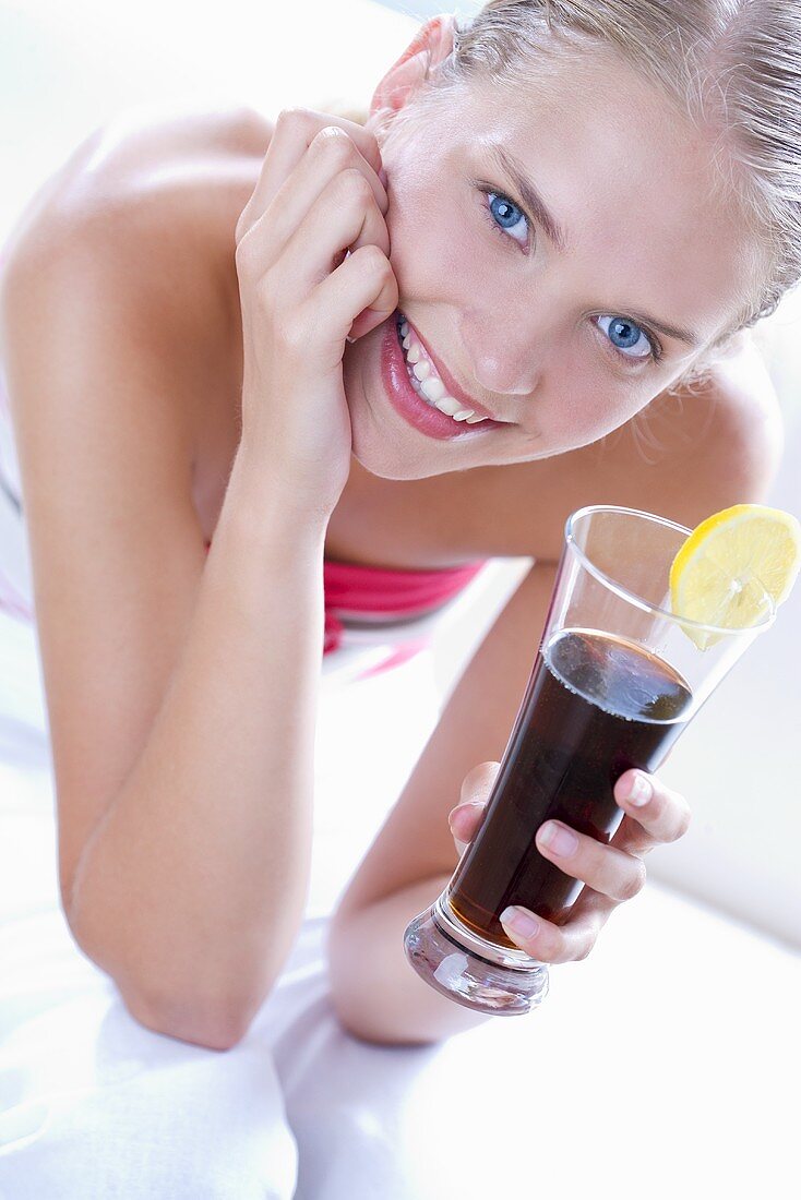 Young woman drinking a glass of cola