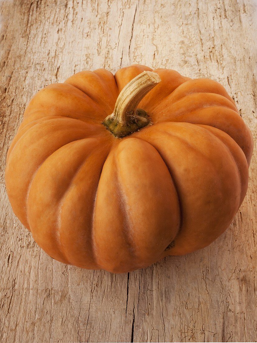 An orange pumpkin on a wooden background