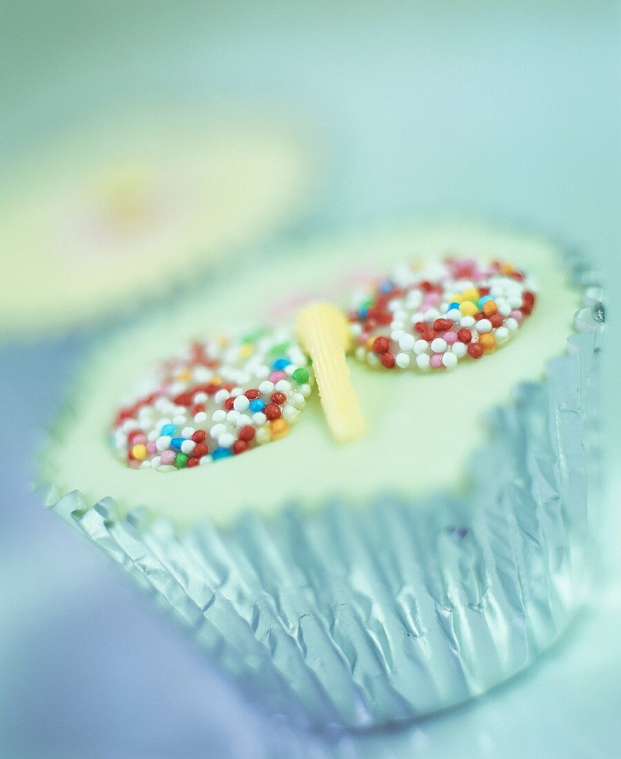 Cupcake mit bunten Zuckerperlen in Silbermanschette