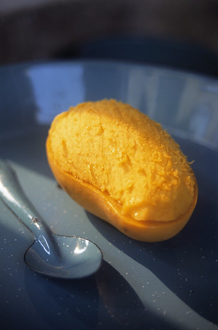 A mango, partly peeled