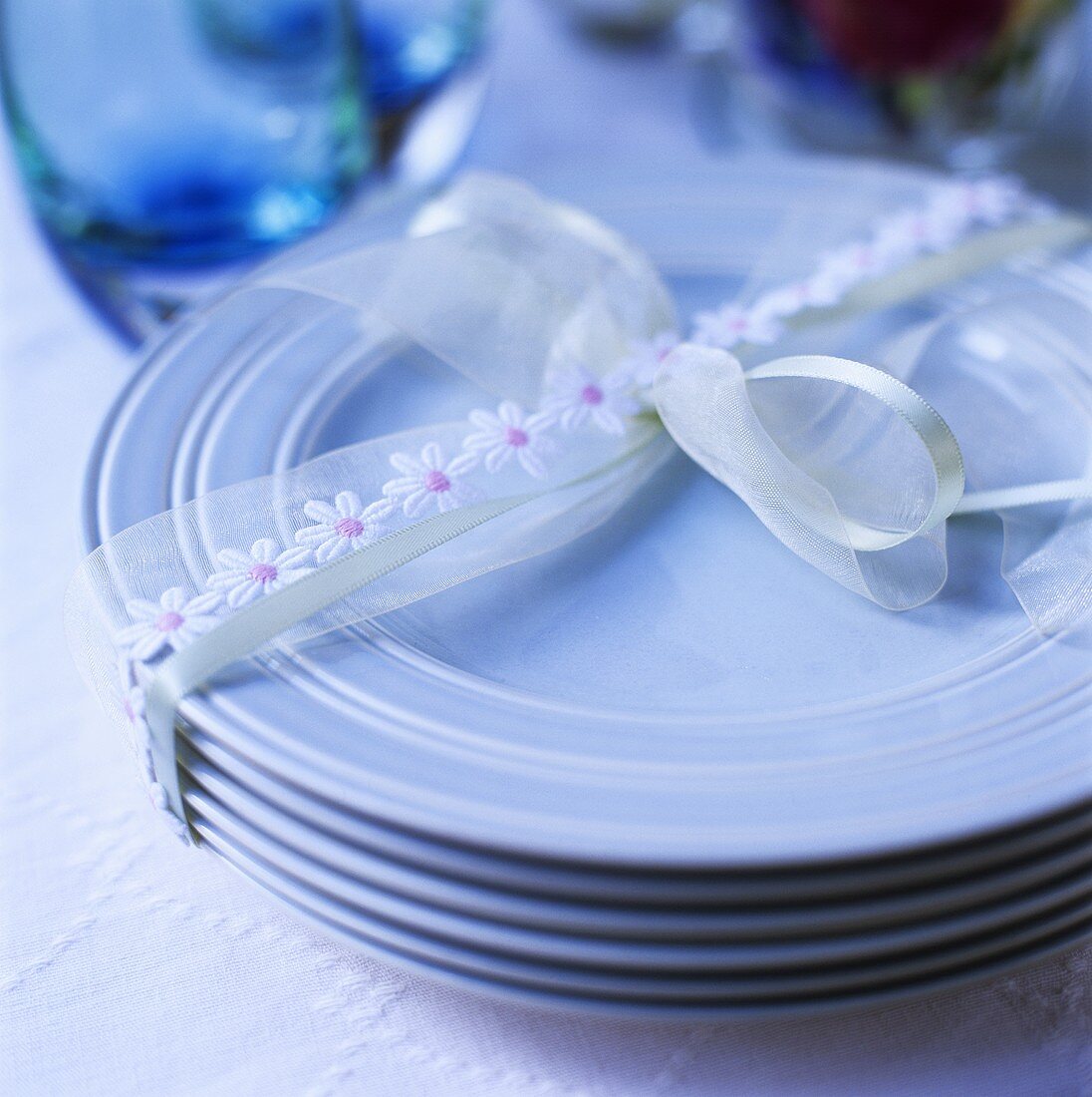 A pile of blue plates tied together with ribbon