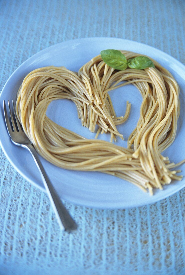 Cooked spaghetti arranged in the shape of a heart