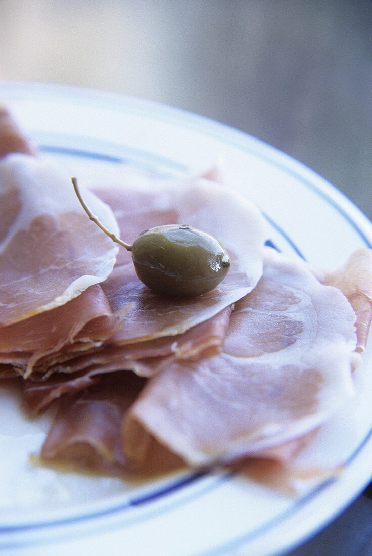 Prosciutto Crudo (roher Schinken aus Italien) und eine Olive