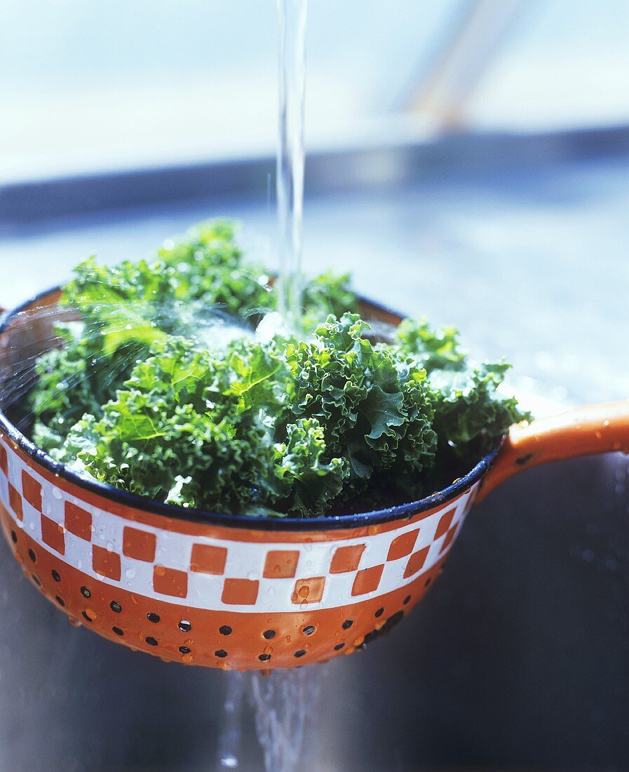 Washing kale in a strainer