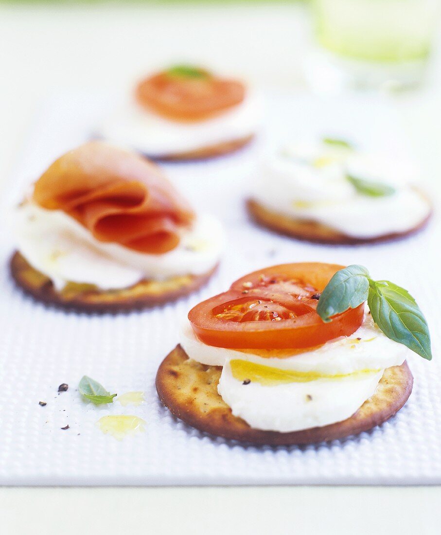 Cracker mit Mozzarella und Tomaten und mit Serranoschinken