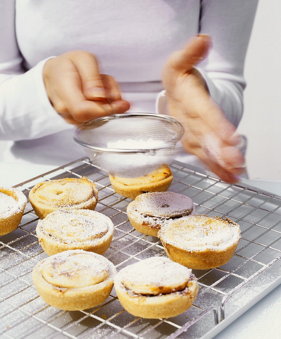 Dusting mince pies with icing sugar
