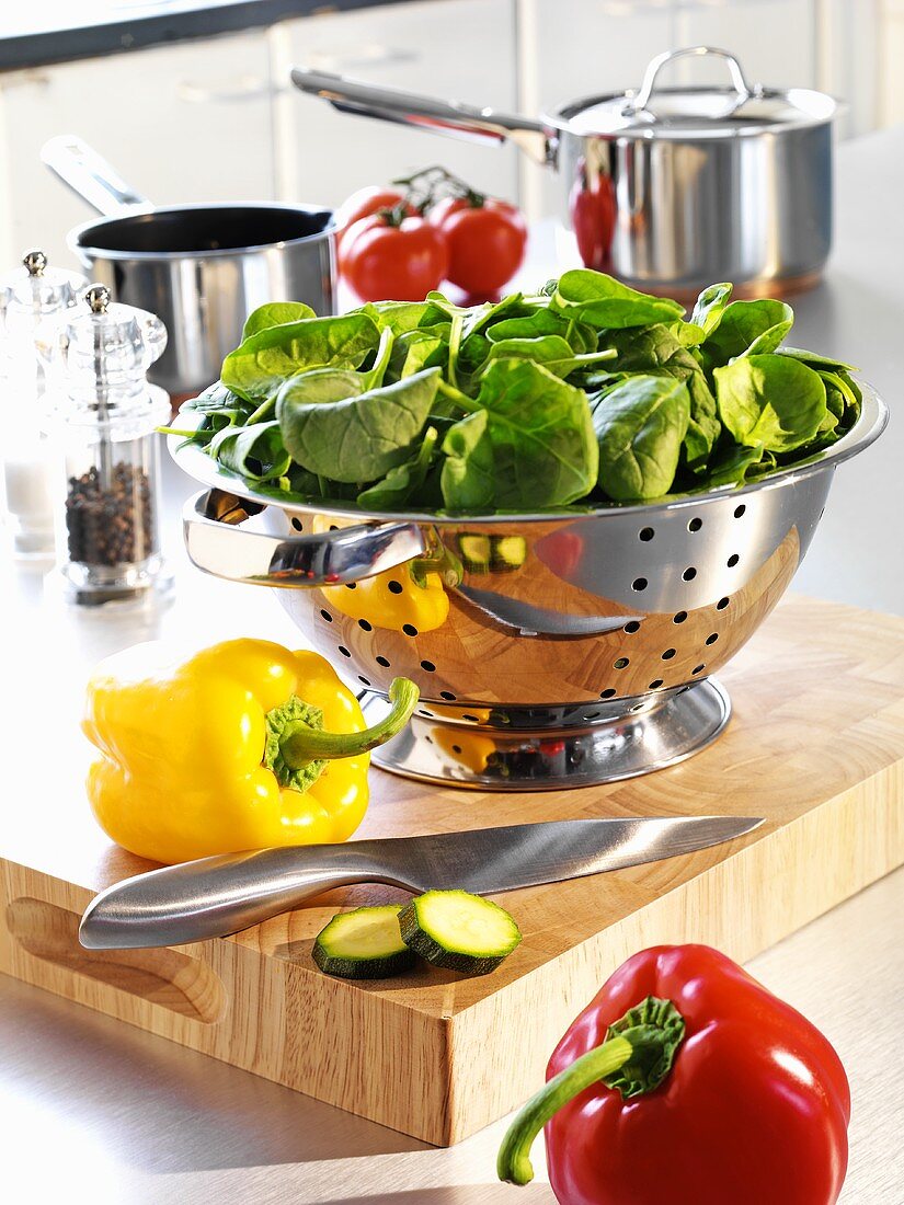 Küchenszene: Gemüse, Messer, Sieb auf Holzbrett in der Küche