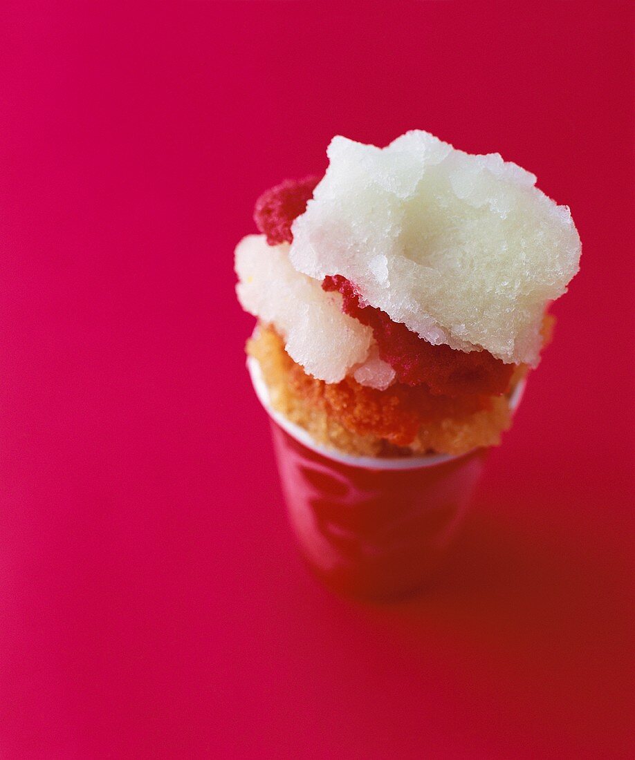 Sorbet in a paper cup against a red background