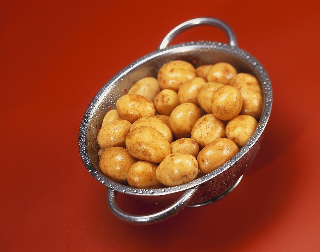 Freshly washed new potatoes in a colander