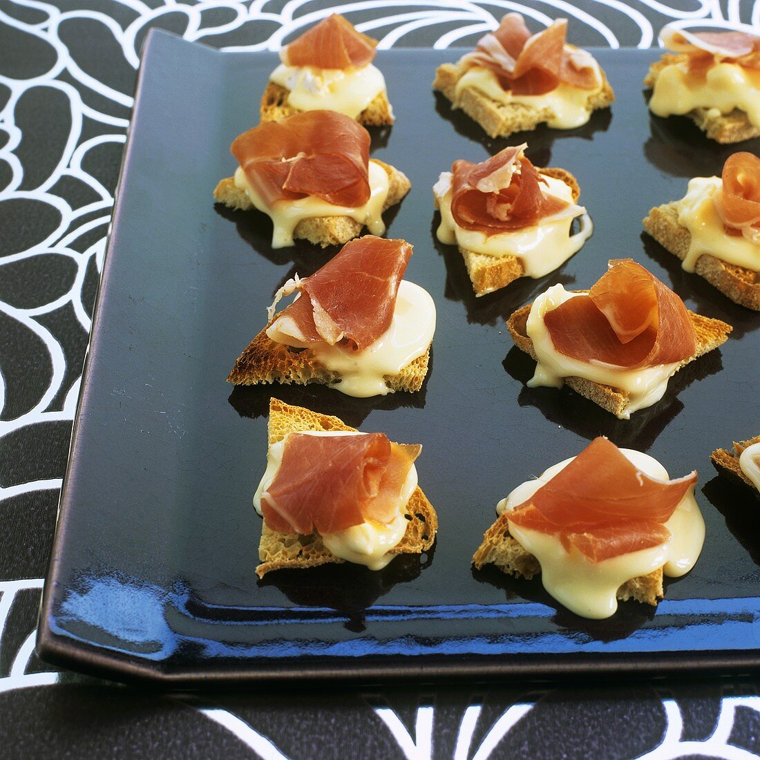 Warme Canapés mit Vacherin-Käse und Prosciutto