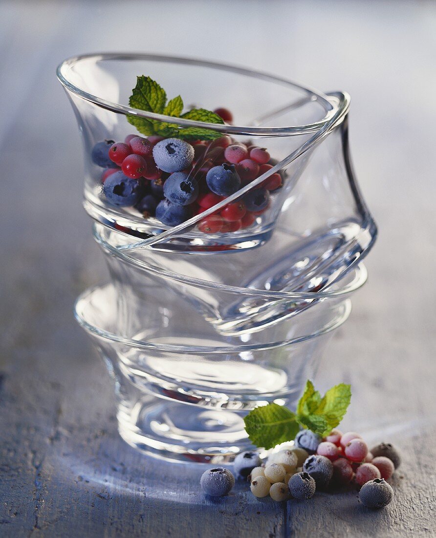 Gestapelte Glasschälchen mit tiefgekühlten Beeren