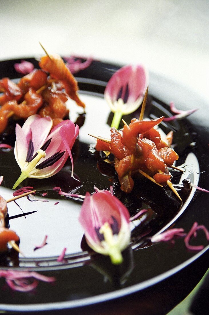 Räucherlachsspiesschen auf Teller mit Tulpen