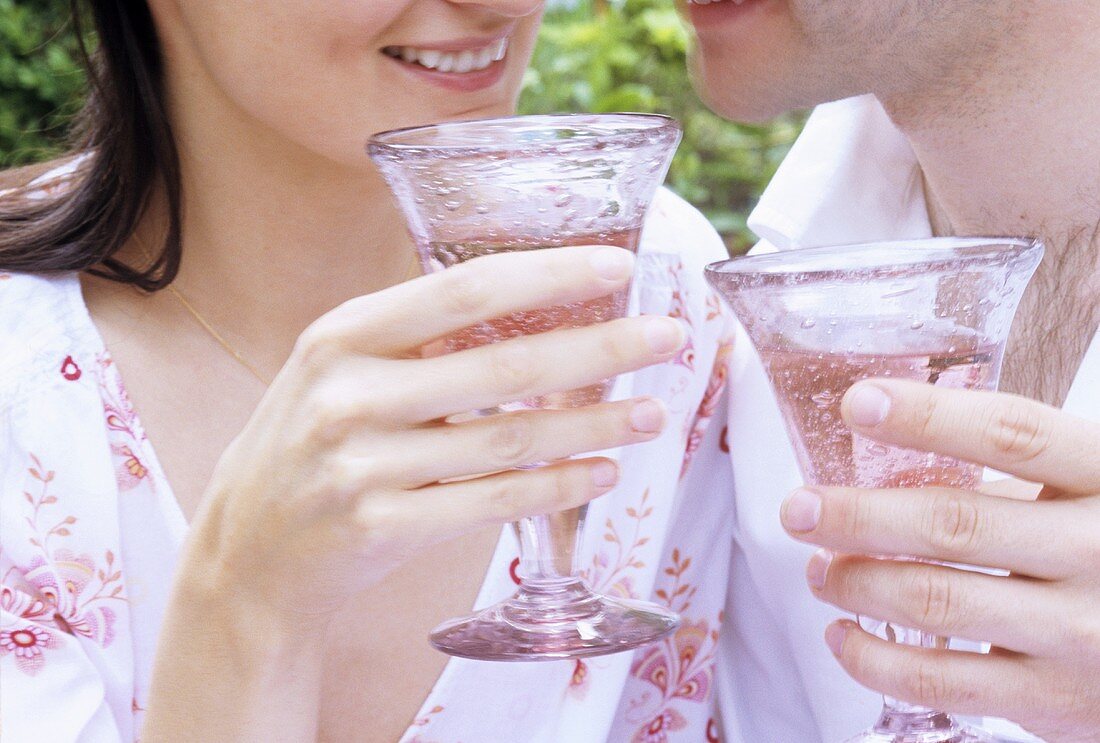 Man and woman clinking glasses of rosé wine (close-up)