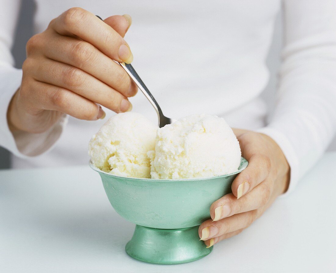 Young woman eating vanilla ice cream