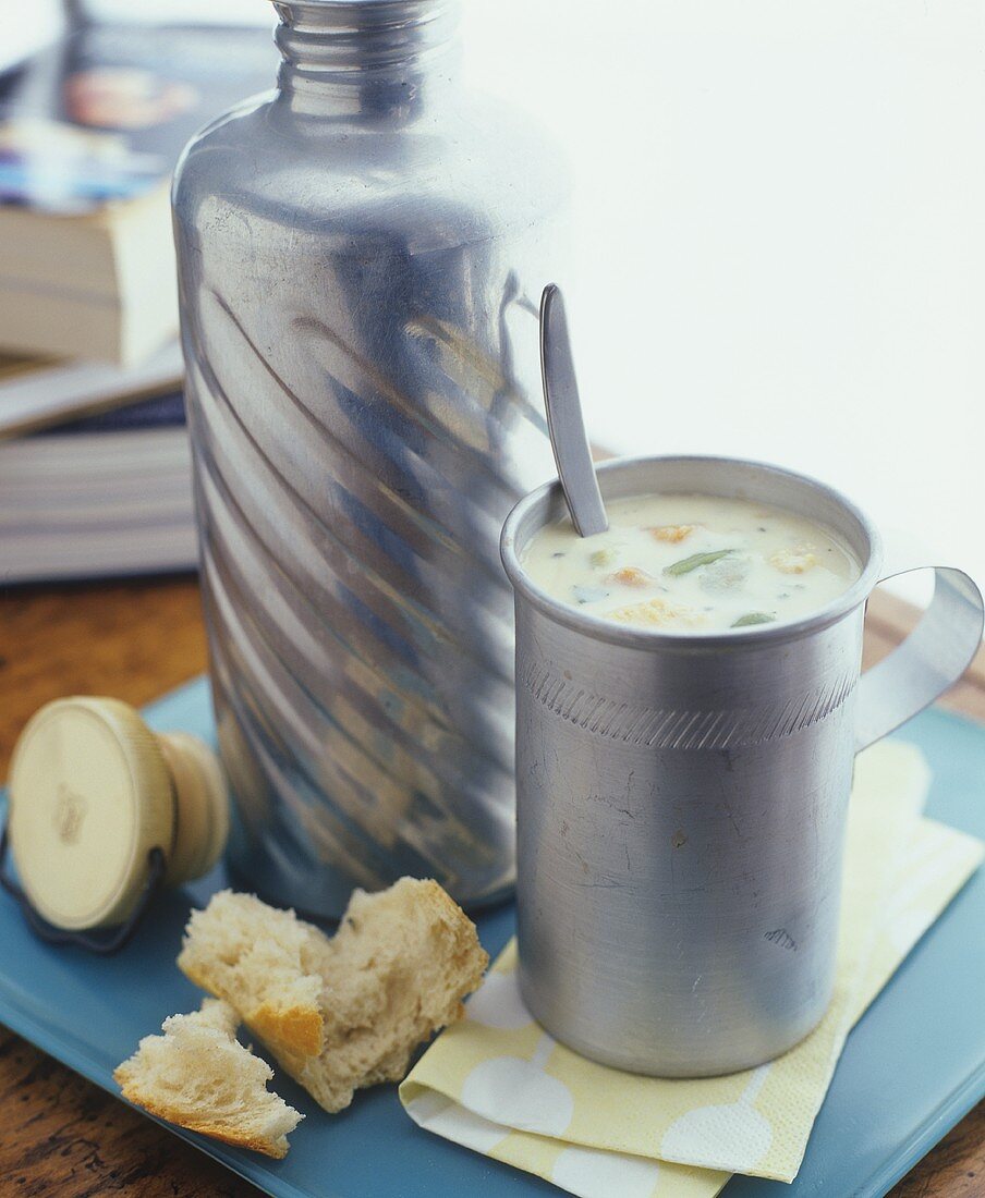 Vegetables soup in Thermos flask and mug, baguette
