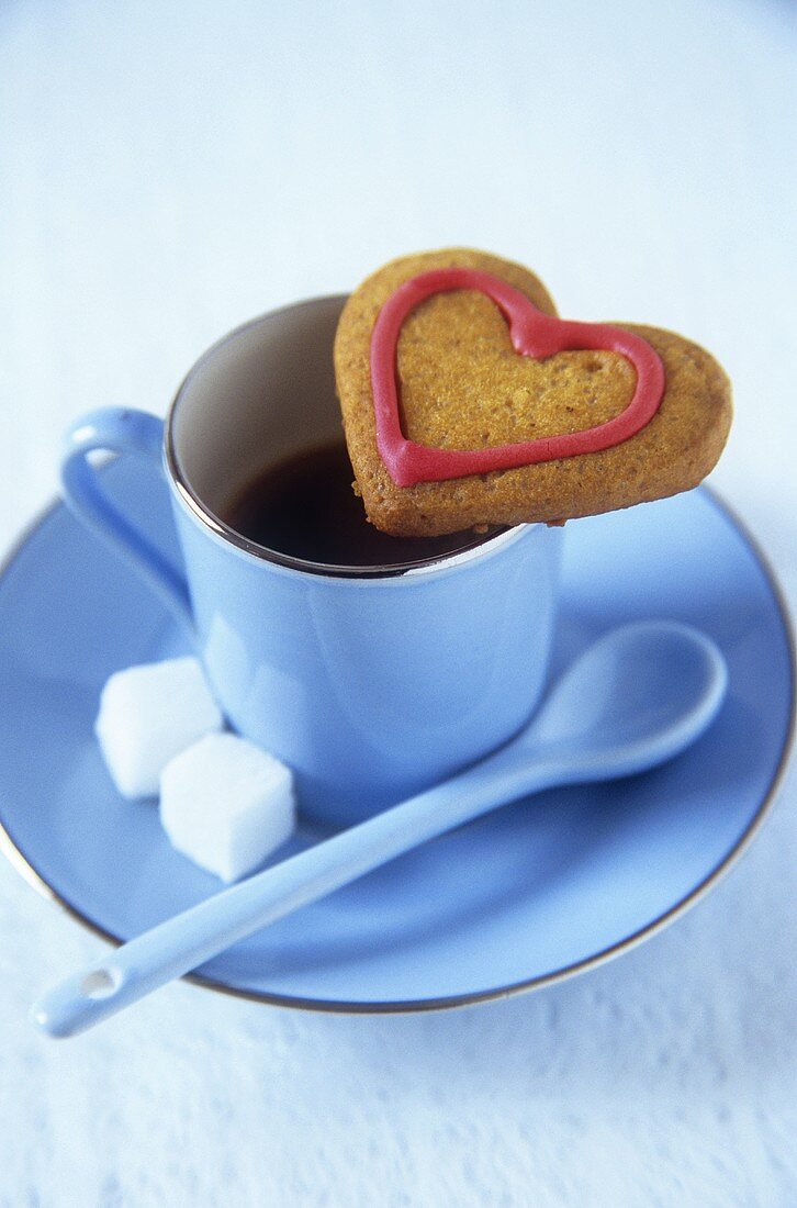 Heart-shaped biscuit and a cup of coffee