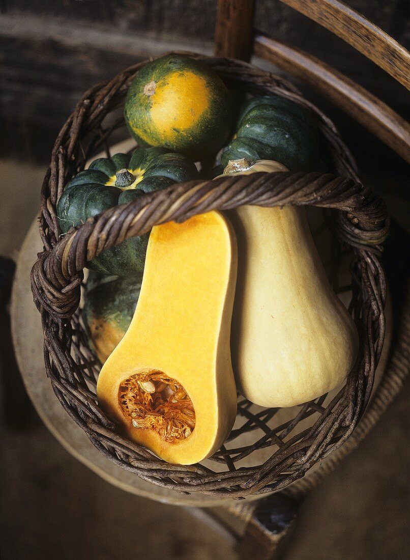 Assorted squashes in a wicker basket (overhead view)