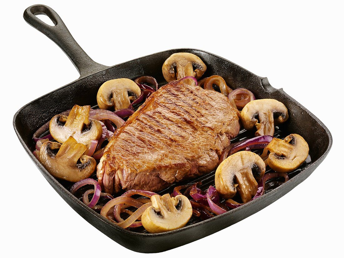 Beef steak with onions and mushrooms in a grill pan