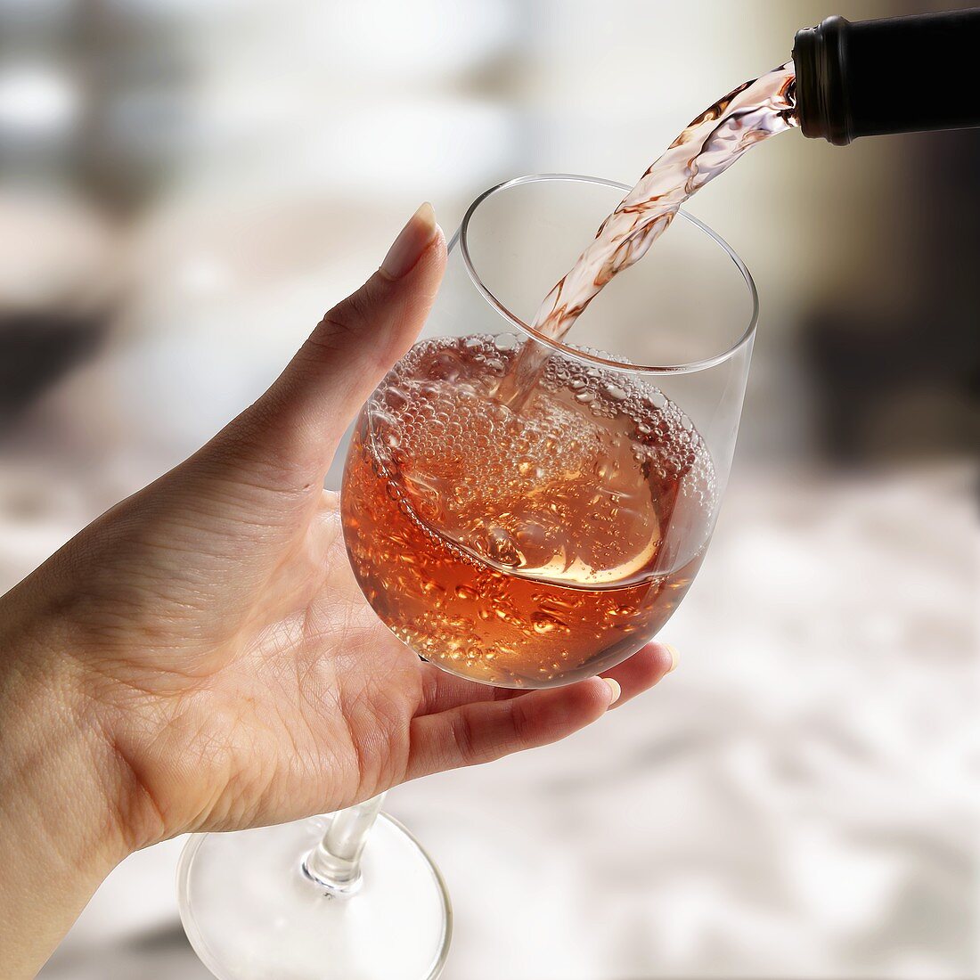 Rosewein in ein Glas gießen