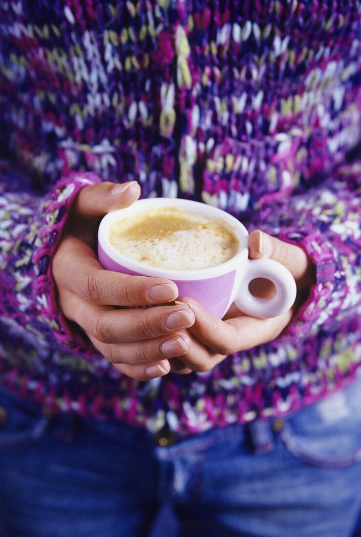 Eine Tasse Cappuccino halten