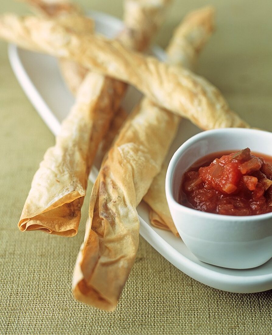 Filo pastry rolls with cheese filling and spicy sauce