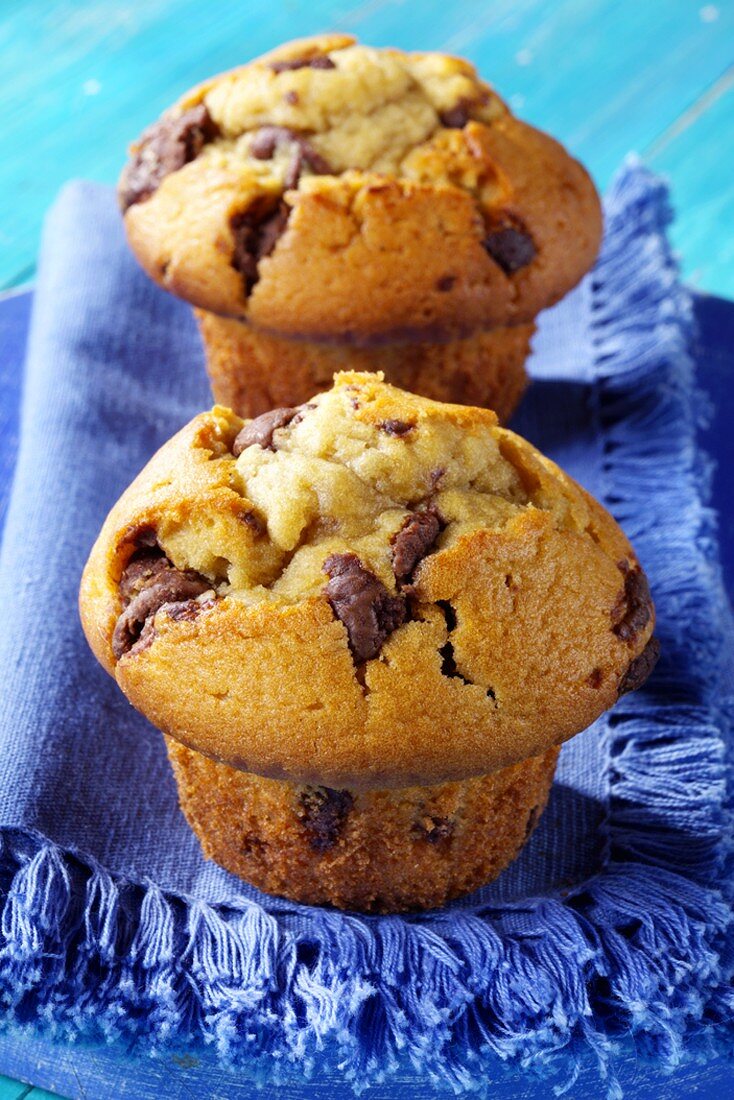 Two chocolate muffins on blue napkin