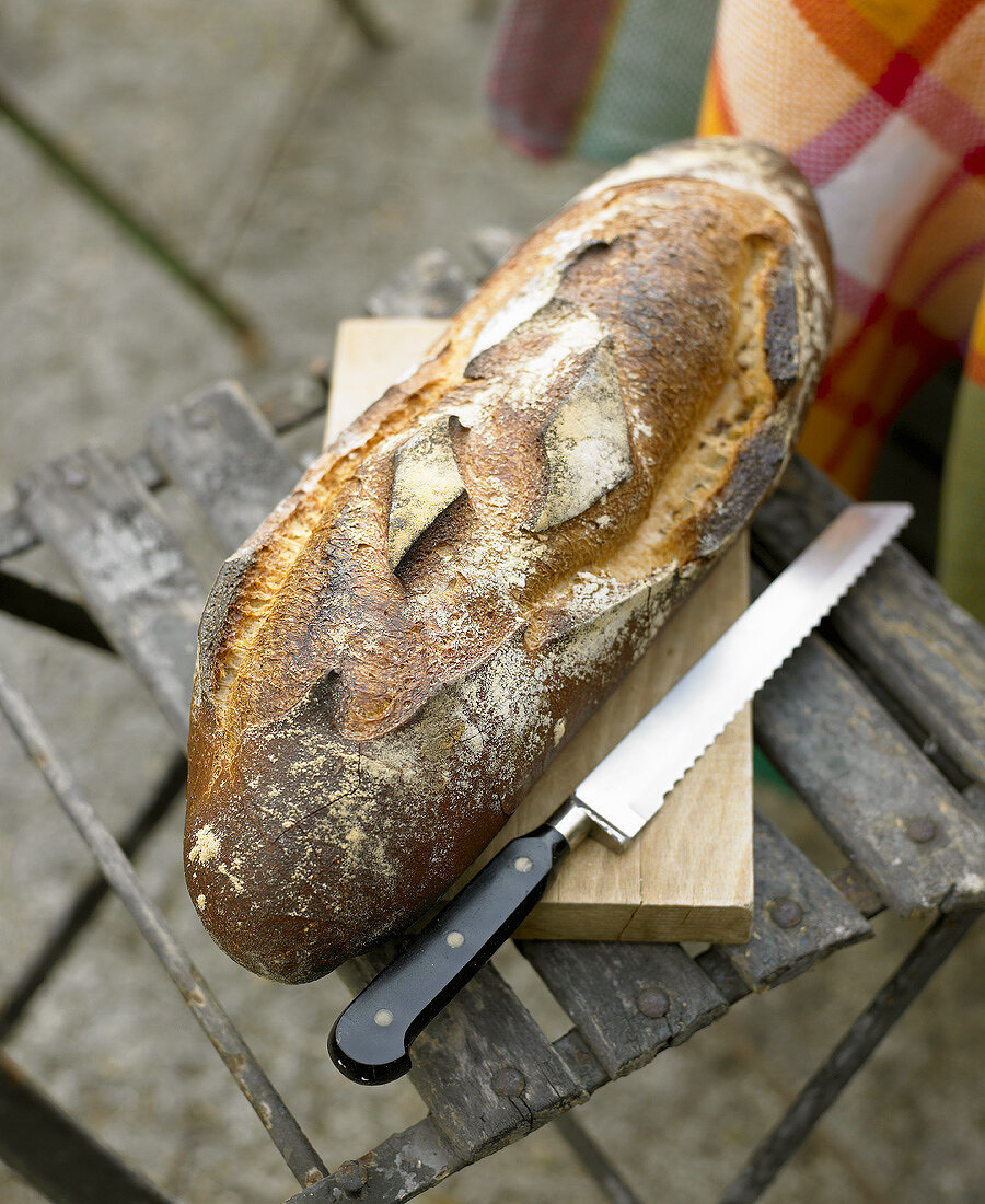 Bread and bread knife on a garden chair