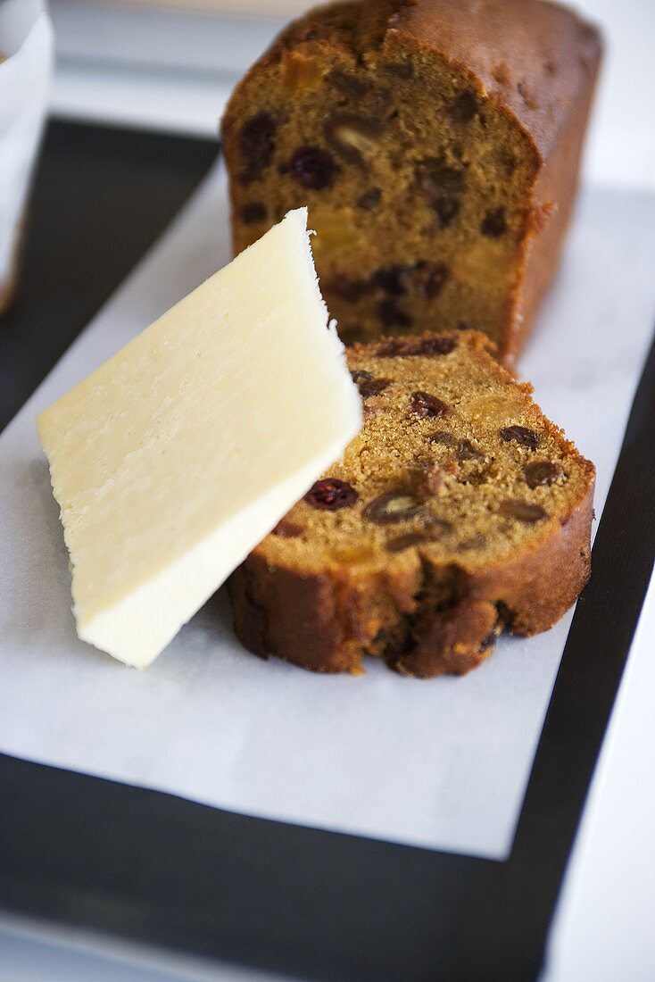 Partly-sliced fruit loaf with a piece of cheese