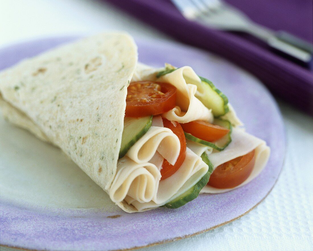 Wraps filled with slices of turkey breast, tomato & cucumber