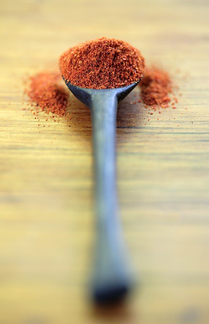 Ground paprika on wooden spoon