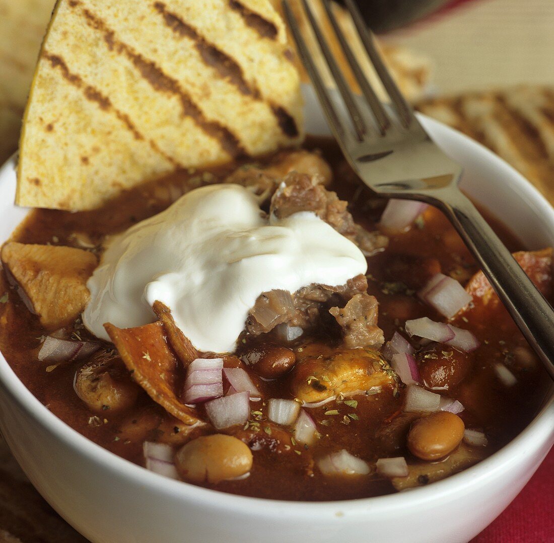 Chicken and chorizo chilli with sour cream and tortilla